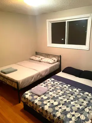 two twin beds in a room with a window at LONG WEEKEND BUMPER OFFER- Transit,Airport,Downtown Minutes Drive in Kitchener