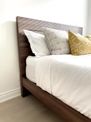 a bed with white sheets and pillows on it at Bright Luxurious 2 Bedroom Apartment in Toronto
