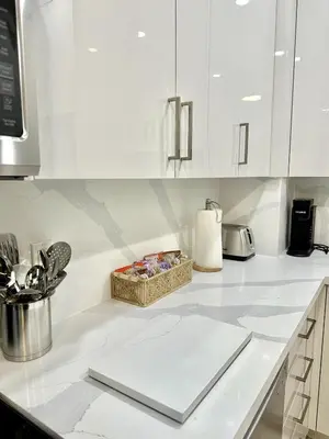 a kitchen with white cabinets and a counter top at Bright Luxurious 2 Bedroom Apartment in Toronto