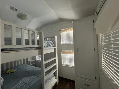 a bedroom with bunk beds and a ladder to a bed at Sherkton Shore Resort in Port Colborne