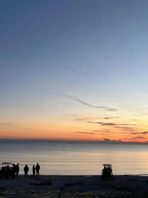 a group of people standing on a beach at sunset at Sherkton Shore Resort in Port Colborne