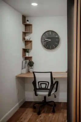 a desk with a chair and a clock on a wall at The Barrie Nook in Barrie