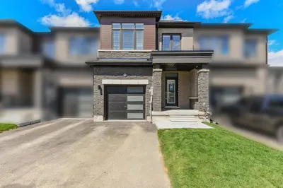 a house with a garage on a driveway at Modern Home 10 mins from Niagara Falls & Main Attraction with Free 2 Parkings in Thorold
