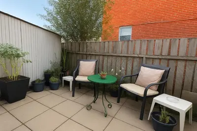 a patio with two chairs and a table and a fence at Vita House - Rogers Stadium and Yorkdale Mall Toronto - quiet and cozy bedrooms in Toronto