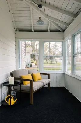 a porch with a couch in a room with windows at SquirrelHaus PEC in Hillier