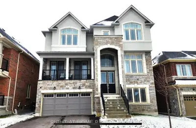 a house with a gray garage door in front at The Rustic Pearl in East Gwillimbury
