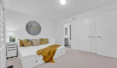 a white bedroom with a bed with a gold blanket at The Rustic Pearl in East Gwillimbury