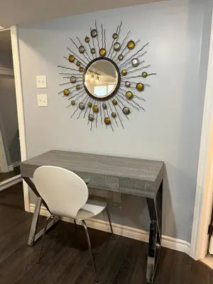 a mirror on a wall with a table and a chair at Just like home 1 bedroom appt in Guelph