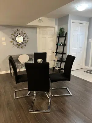 a dining room with a glass table and black chairs at Just like home 1 bedroom appt in Guelph