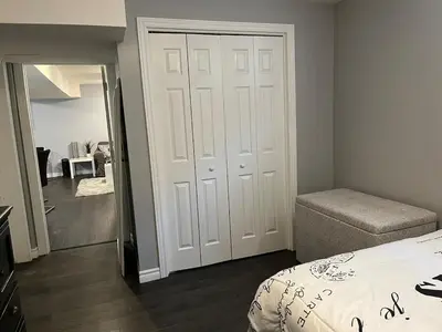 a bedroom with a bed and a door with a mirror at Just like home 1 bedroom appt in Guelph