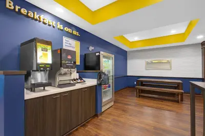 a fast food restaurant with a cash register and a bench at Days Inn & Suites by Wyndham Lindsay in Lindsay