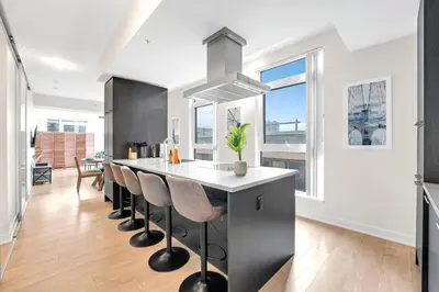 a kitchen with a island with stools and a counter top at Luxe 5bd Unit sleeps 11 - Hospitals MTCC TTC ACC in Toronto