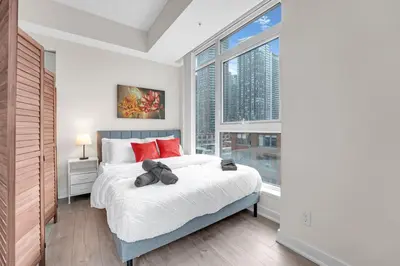 a bedroom with a bed and a large window at Luxe 5bd Unit sleeps 11 - Hospitals MTCC TTC ACC in Toronto