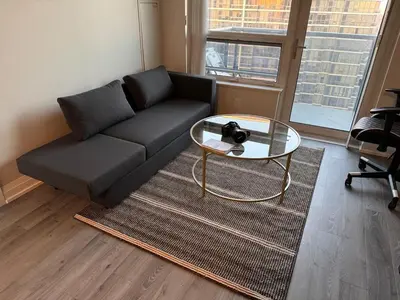 a living room with a couch and a glass table at Condo at Yonge-Sheppard Station, North York in Toronto