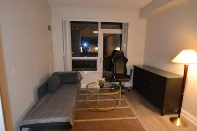 a living room with a couch and a table at Condo at Yonge-Sheppard Station, North York in Toronto