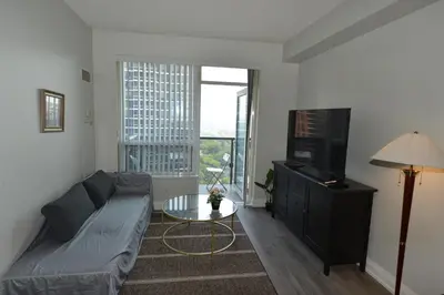 a living room with a couch and a tv at Condo at Yonge-Sheppard Station, North York in Toronto