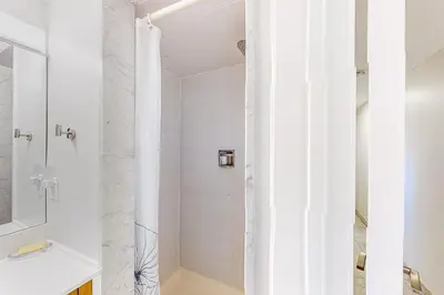 a white bathroom with a shower and a sink at Wintergreen 122 in Blue Mountains