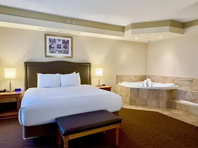 a hotel room with a bed and a bath tub at Waterloo Suites Hotel, Trademark Collection by Wyndham in Waterloo