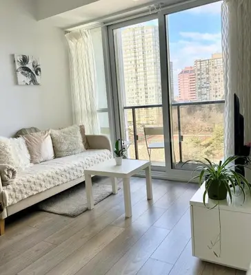 a living room with a couch and a table at Modern & Stylish Condo Downtown in Mississauga
