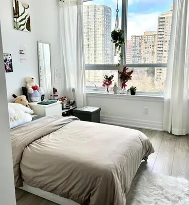 a bedroom with a bed and a large window at Modern & Stylish Condo Downtown in Mississauga