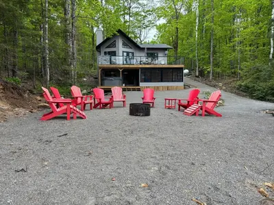 a group of red chairs in front of a house at Wiley Woods Cottage in Minden