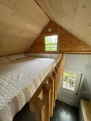 a bed in the attic of a cabin at Wiley Woods Cottage in Minden