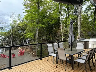 a deck with a table and chairs and an umbrella at Wiley Woods Cottage in Minden
