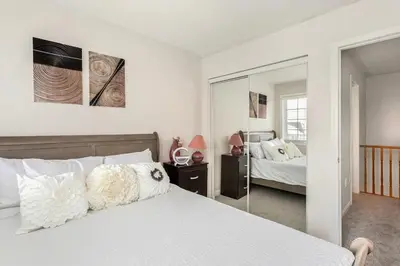 a bedroom with a bed and a mirror at The Mt Pleasant Residence - 'Your Cozy Away-Home' in Brampton