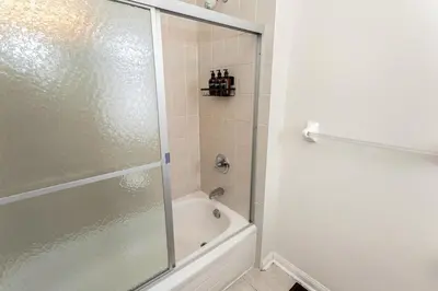 a bathroom with a shower and a white tub at The Mt Pleasant Residence - 'Your Cozy Away-Home' in Brampton