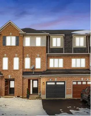 a brick apartment building with a garage at The Mt Pleasant Residence - 'Your Cozy Away-Home' in Brampton