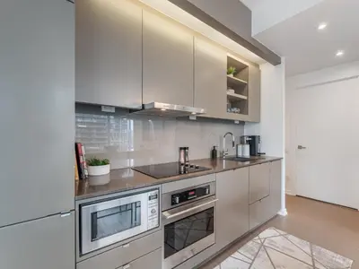 a kitchen with white cabinets and stainless steel appliances at The Aventi Suites - Downtown Toronto - Across TIFF Bell Lightbox in Toronto
