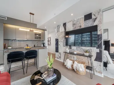 a kitchen and living room with a fireplace and a table at The Aventi Suites - Downtown Toronto - Across TIFF Bell Lightbox in Toronto