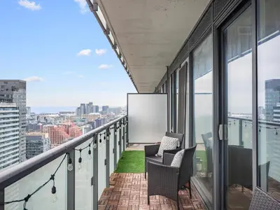 a balcony with two chairs and a sign on a building at The Aventi Suites - Downtown Toronto - Across TIFF Bell Lightbox in Toronto