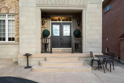 a front door of a house with a table and chairs at Private Bright Coach House - Near Pearson Airport & Downtown Toronto in Brampton