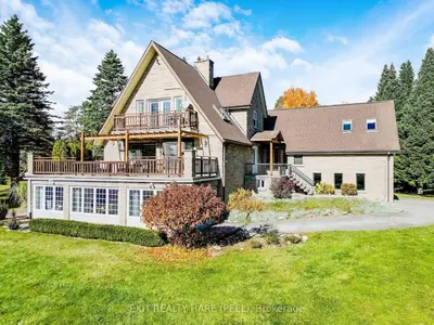 a large house with a porch and a deck at Mono Farmhouse in Caledon