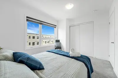 a bedroom with a bed and a large window at Ritzy 3BR Home with Balcony Near Burlington Pier in Burlington