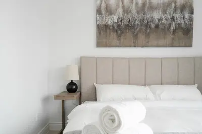 a bedroom with a bed with a painting on the wall at Luxury 2 Bedroom 3 Bed Family Friendly Oasis with Smart Technology in Brampton