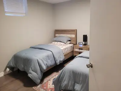 a bedroom with two beds and a table with a tv at Cozy 2 Bed Rooms Apartment in Prime Location! in Mississauga