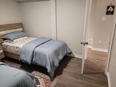 a bedroom with a bed in a room with wooden floors at Cozy 2 Bed Rooms Apartment in Prime Location! in Mississauga
