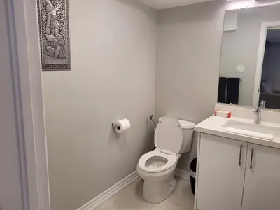 a white bathroom with a toilet and a sink at Cozy 2 Bed Rooms Apartment in Prime Location! in Mississauga