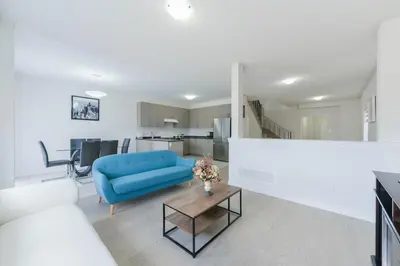 a living room with a blue couch and a table at Entire 4BR Detached Home 15 Mins from the Falls, in Thorold, Perfect for 10 guests in Thorold