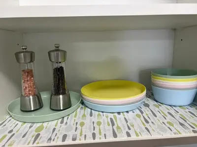 a shelf with plates and bowls on a table at Entire 4BR Detached Home 15 Mins from the Falls, in Thorold, Perfect for 10 guests in Thorold