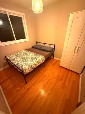 a bedroom with a bed in a room with a wooden floor at YKF Airport Home-FREE FAST WIFI-FREE PARKING in Hespeler