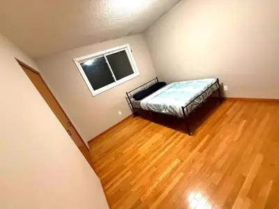 a bedroom with a bed in a room with a wooden floor at YKF Airport Home-FREE FAST WIFI-FREE PARKING in Hespeler