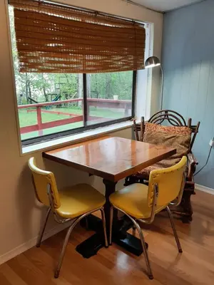 a dining room table with two chairs and a window at Wymbolwood Lodge in Tiny