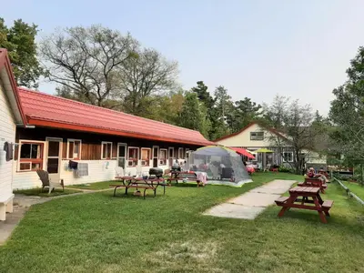 a group of picnic tables in front of a building at Wymbolwood Lodge in Tiny