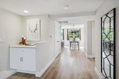 a white kitchen with a counter and a dining room at Wintergreen Spacious 2 Story Townhome Sauna 2 Min Walk to Village in Blue Mountains