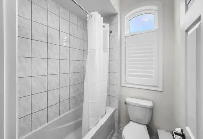 a bathroom with a toilet and a tub and a window at Modern Comfort in Clarington in Newcastle