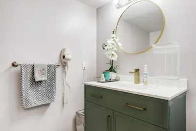 a bathroom with a green vanity and a mirror at Luxury & private 3 bed basement unit kitchen, wifi, park, mall in London