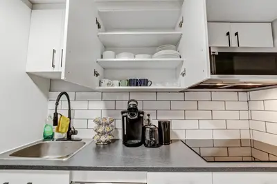 a kitchen counter with white cabinets and a sink at Luxury & private 3 bed basement unit kitchen, wifi, park, mall in London